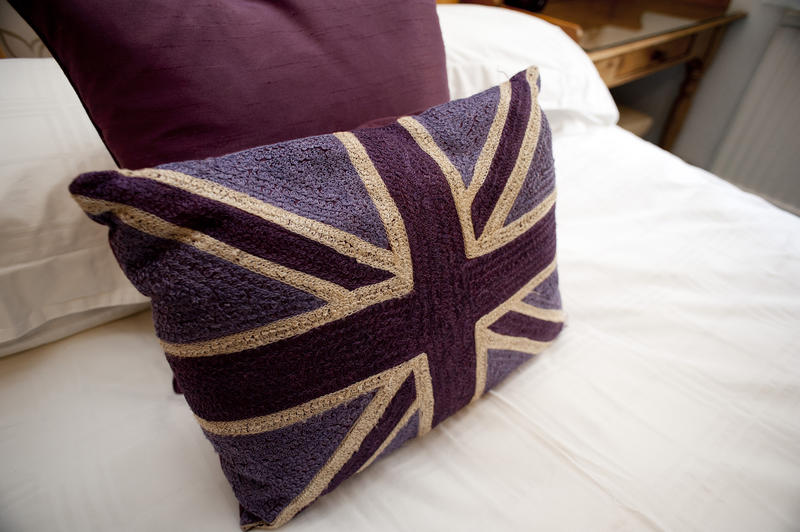 Patriotic British pillow case on a bed with a copy of the Union Jack or Union Flag of the United Kingdom in a themed bedroom