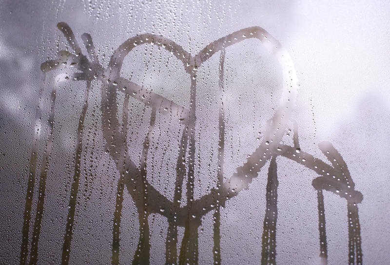 Valentine Concept - Close up Heart with Arrow on Misty Glass Window, Reflected by Light From Outside.