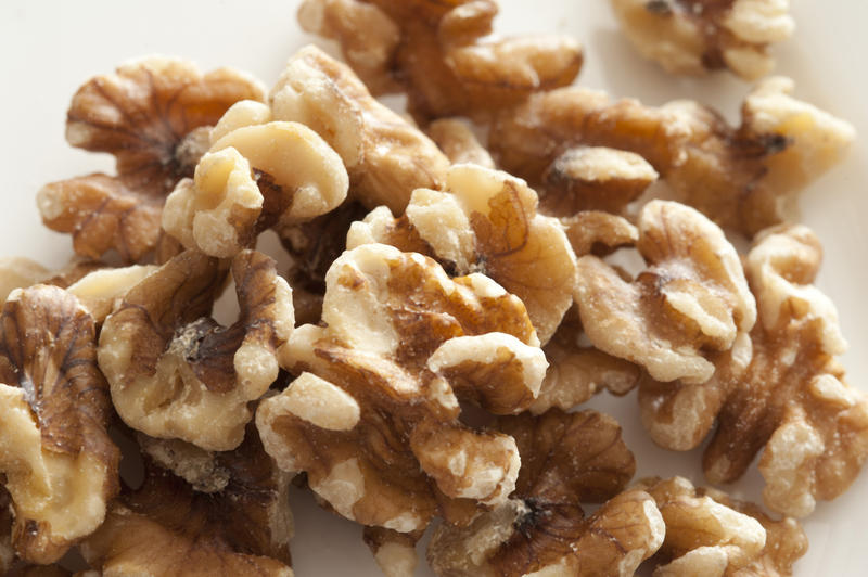 Close Up High Angle Still Life of Shelled Walnut Halves Piled on White Background