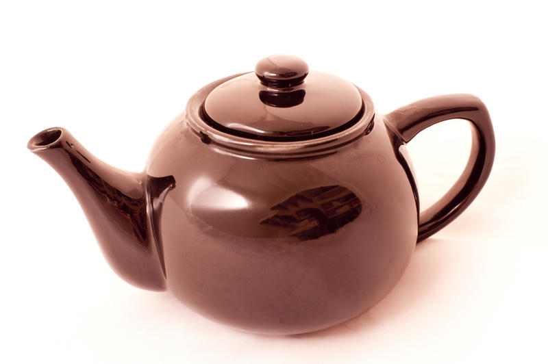 Close-up of a warm copper-colored basic teapot for everyday use, on white