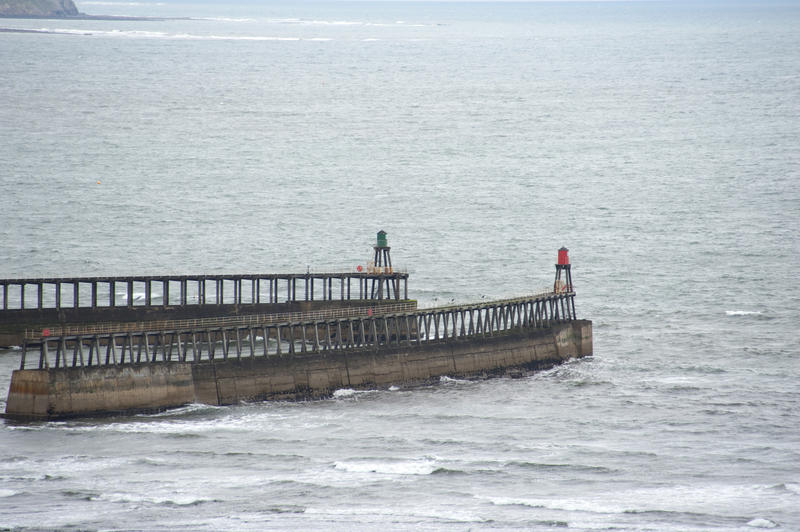 Concrete piers with lights reaching into a rough sea