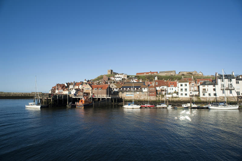 Lifeboat station in Whitby harbour with a picturesque view of the town buildings and wharf