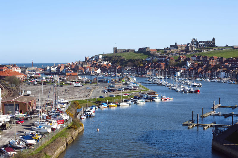 Picturesque landscape view of Whitby upper harbour with its marina and moored pleasure boats to Tate Hill and the abbey ruins
