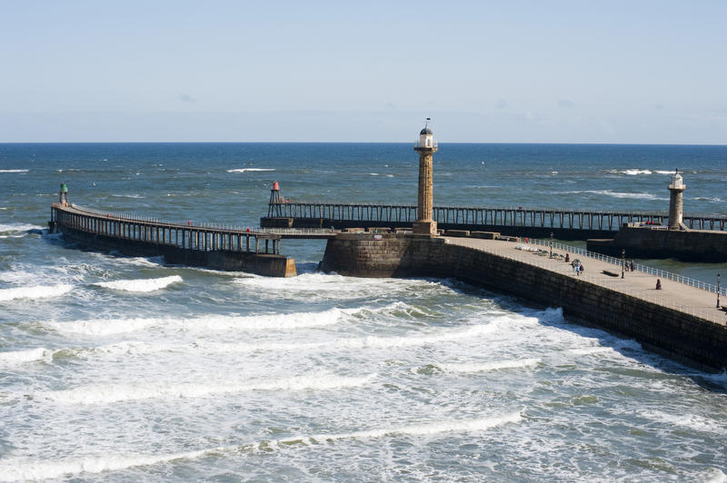 Scenic view of the Whitby harbour outer breakwaters with their two guiding beacons protecting the harbour entrance from the waves and surf