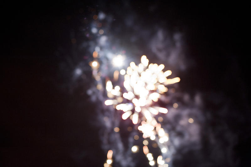 Bright festive background with a white fireworks bokeh of a bursting rocket in the night sky to celebrate a holiday or festival