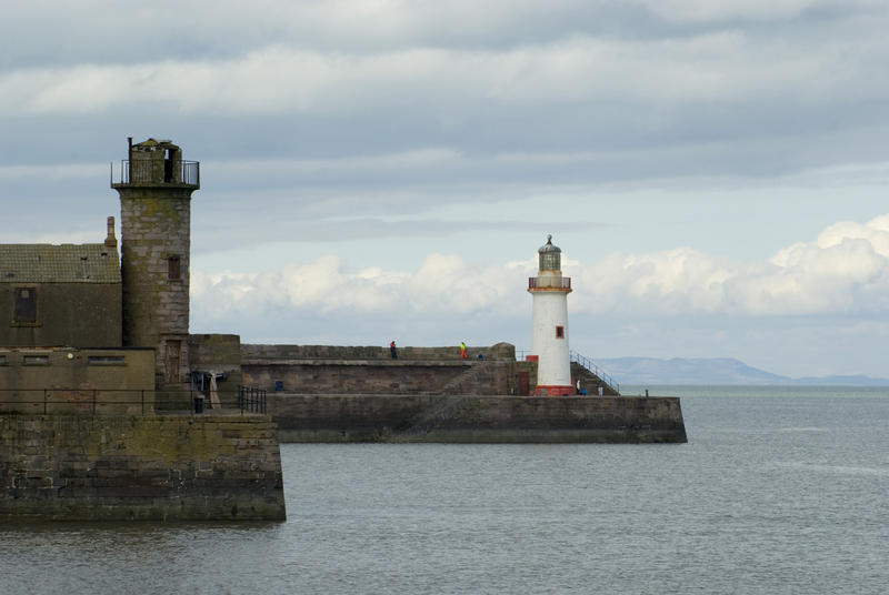 Sea wall at Whitehaven harbour guarded on either side by the port and starboard coloured beacons to guide ships in safely