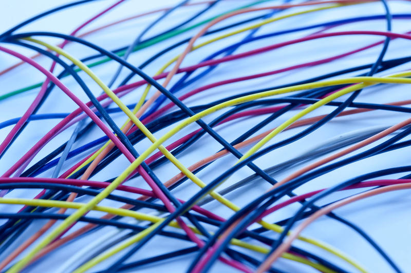 Close Up of Thin Multi Colored Wires Criss Crossed on Plain Background in Cool Blue Tone Ideal for Backgrounds