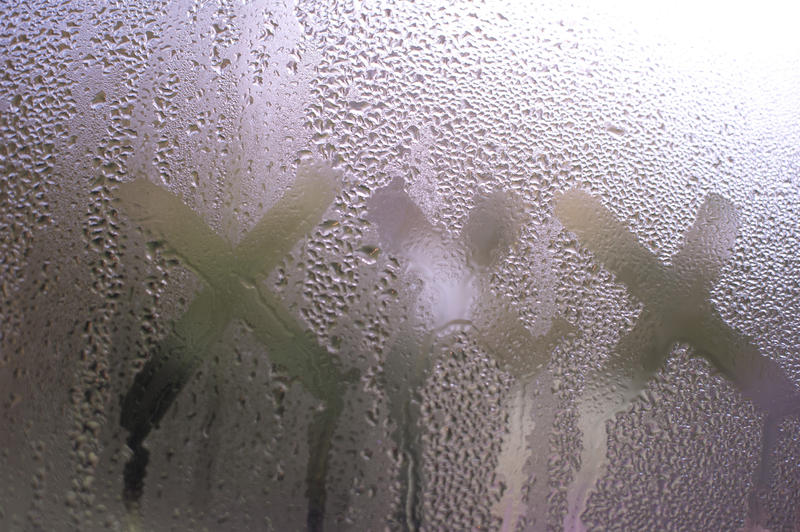 Close up Shot of Conceptual Handwritten XXX on Misty Glass Window, Reflected with Light From Outside.