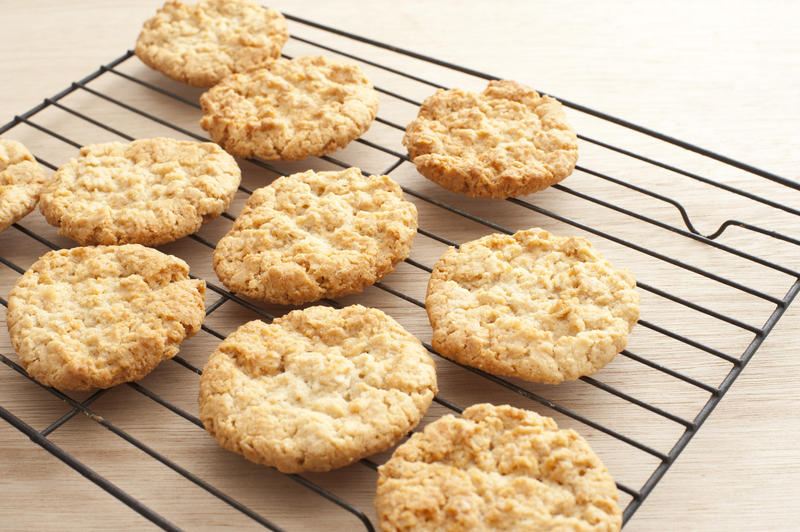 Freshly baked assortment of delicious crunchy cookies on oven tray over wooden table