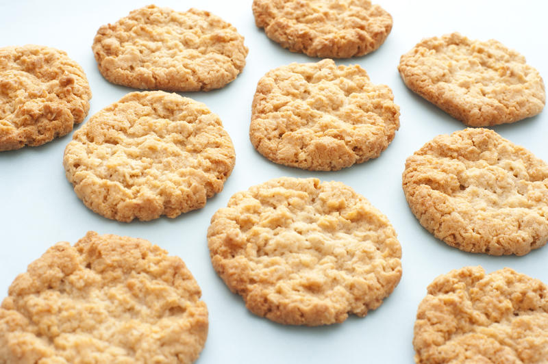 Tasty homemade oatmeal cookies spread out on a white surface viewed low angle with shallow dof