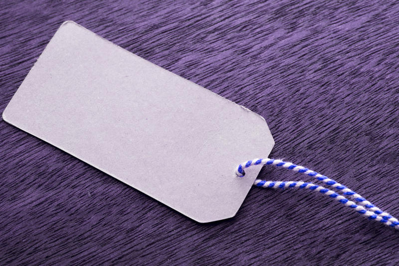 Close up shot of a gift name tag on a string on purple background