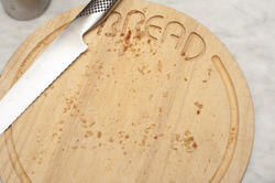 17149   Circular wooden bread board with crumbs and knife