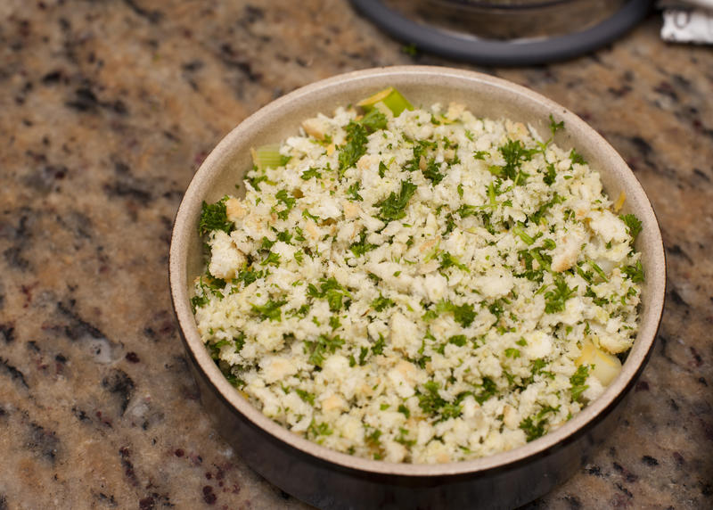 Round casserole dish on granite counter top served with chopped herbs in kitchen