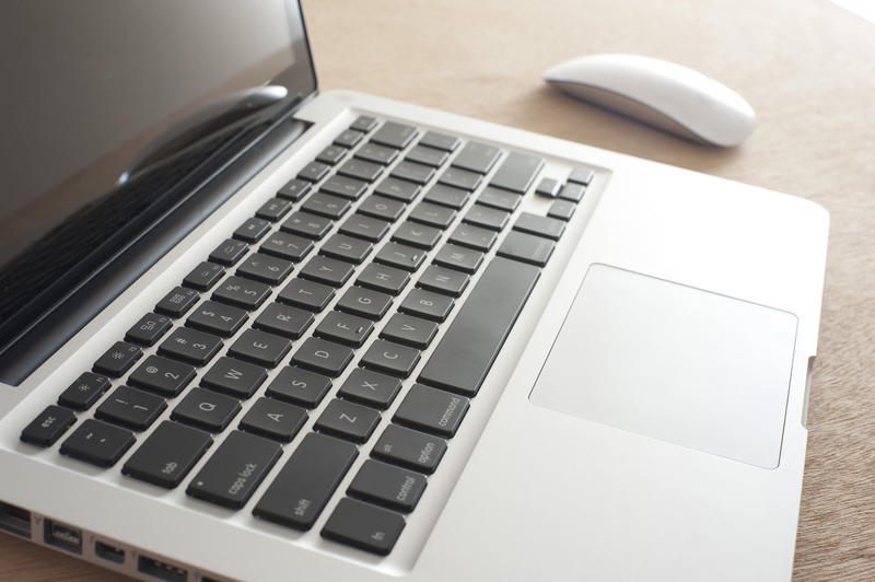 Open laptop computer and mouse viewed obliquely across the black keyboard in a close up view