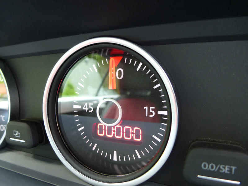 Lap timer on the black dashboard of a modern car with a round dial showing zero on the digital readout