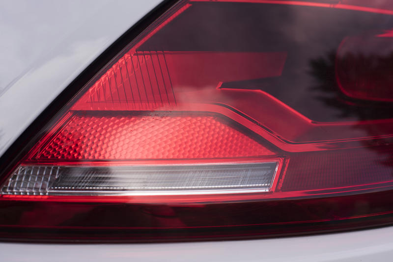 Curved modern car rear light with a red lens with white indicator insert in a close up view