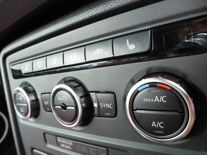 Close up on automobile air conditioning and heating controls with rectangular and circular buttons
