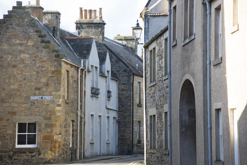 Old two story stone brick homes along tight curved road in Saint Andrews, Scotland
