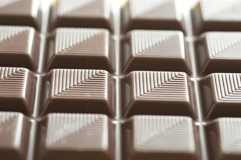Textured bar of chocolate candy viewed at an oblique angle to emphasise the striped pattern, with selective focus