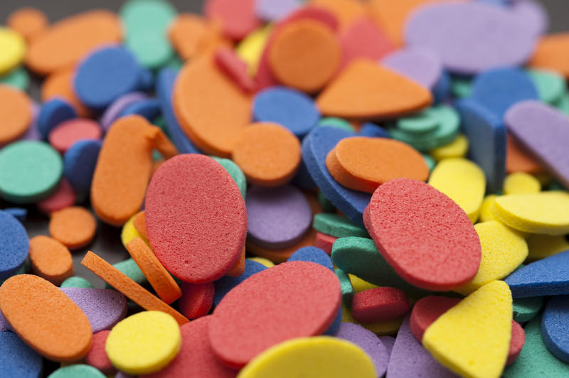 Close up view on various shaped tiny foam yellow, red, blue, purple and green objects