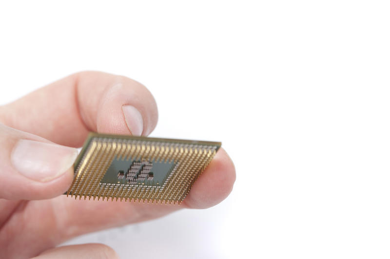 Man holding computer CPU with his fingers, close-up image on white background with copy space