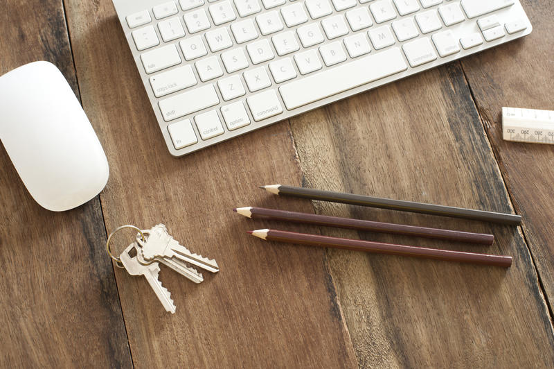 Artist supplies with keys and computer on desk