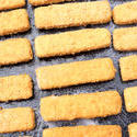 12996   Breaded fish fingers on an baking tray