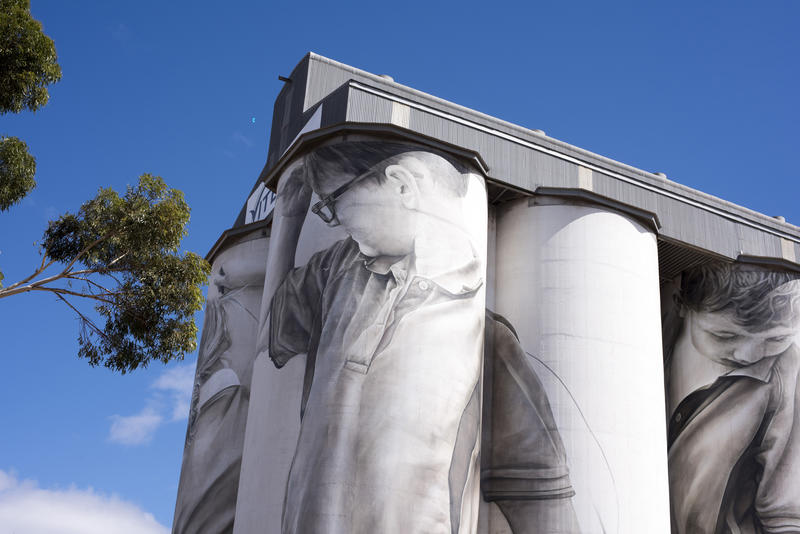 Tall agricultural grain silos at Coonalpyn in South Australia for storing harvested grain and cereal, low angle against a blue sky