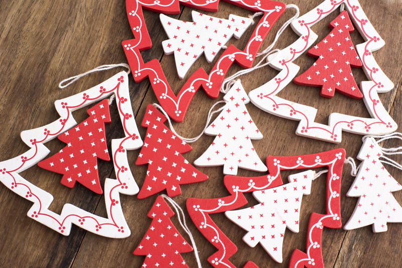 Colorful red polka dot Christmas tree decorations lying ready to be hung on a wooden table viewed high angle