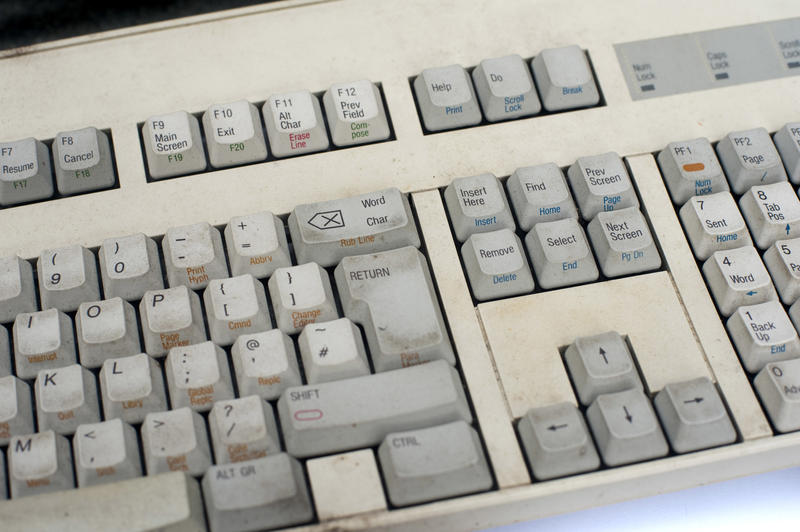 Dirty old white computer keyboard with grey buttons, close-up image
