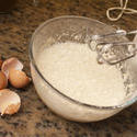 12998   Glass bowl with frothy batter beside egg shells