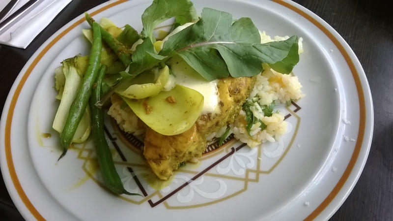 Delicious Asian style cooked string beans, peppers and fried fish garnished with greens on plate