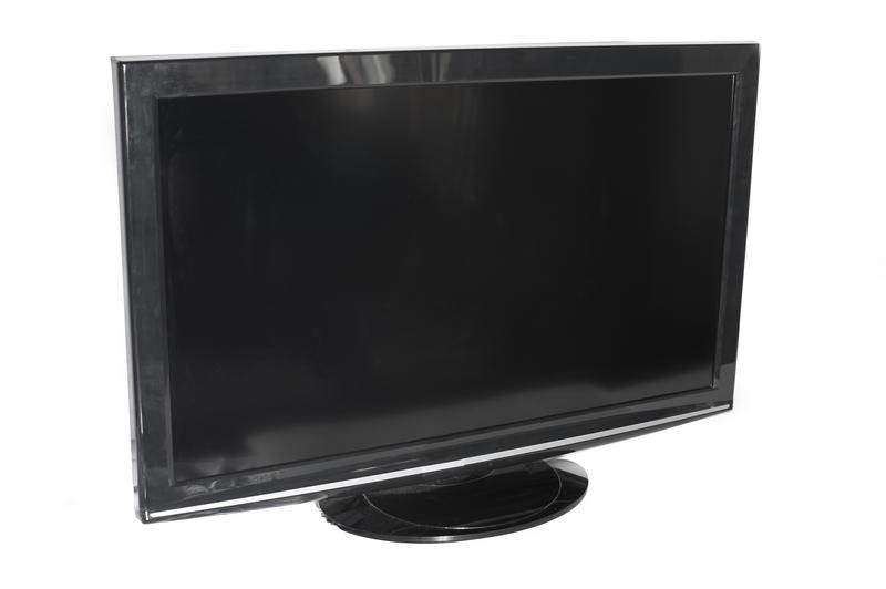 Flat panel television set with a blank black screen viewed at an oblique angle over white