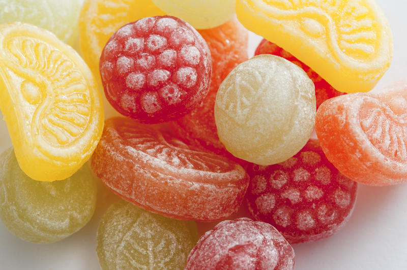 Close up on sweet fruity candies in the shape of oranges, lemons, limes and raspberries
