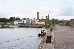 12851   Boat at pier with old cathedral in background