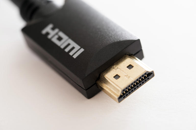 HDMI connector plug with body of black plastic and white label close-up on white background