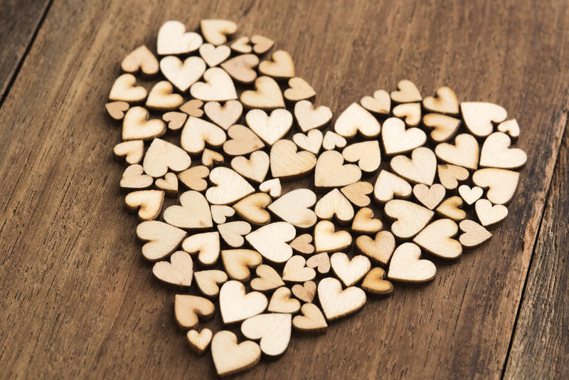 Heart shaped wooden pieces formed in shape of big heart over unpainted wooden surface background
