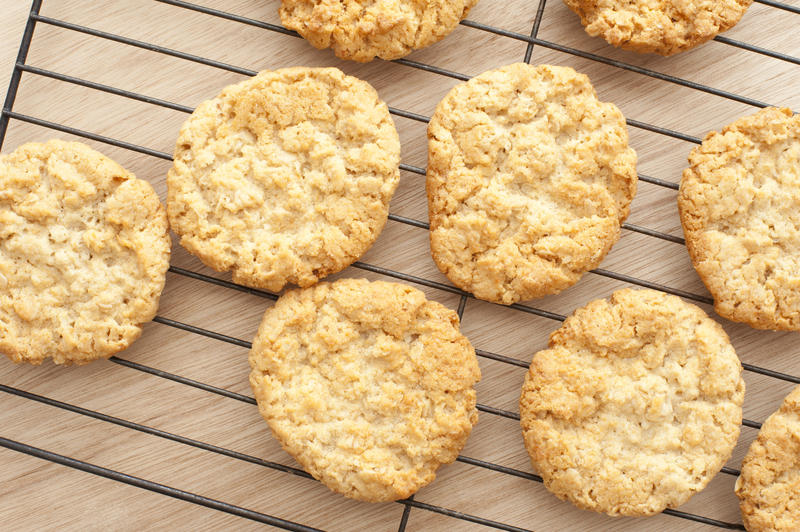 Top down view on freshly baked assortment of delicious home made crunchy cookies on oven tray over wooden table