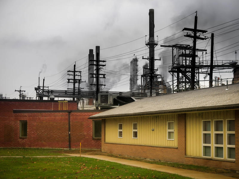 <p>Industrial office buildings, smoke stacks, wires, support beams against a gray, dismal sky. </p>
