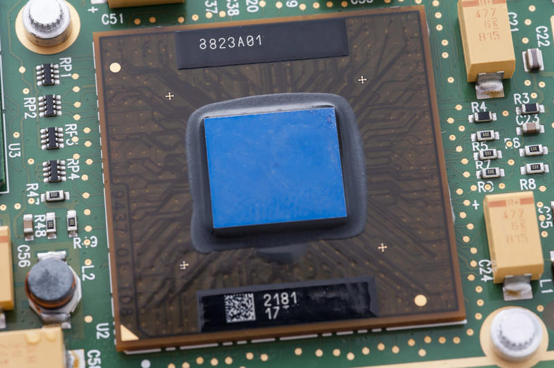 Close-up view of laptop CPU chip with blue core on motherboard