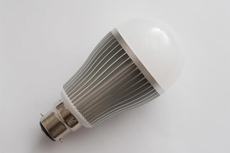 Energy efficient LED lamp with B22 base close-up on white surface background