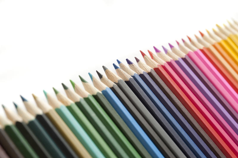 Selective focus tight crop on line of various colored pencils with white copy space above them