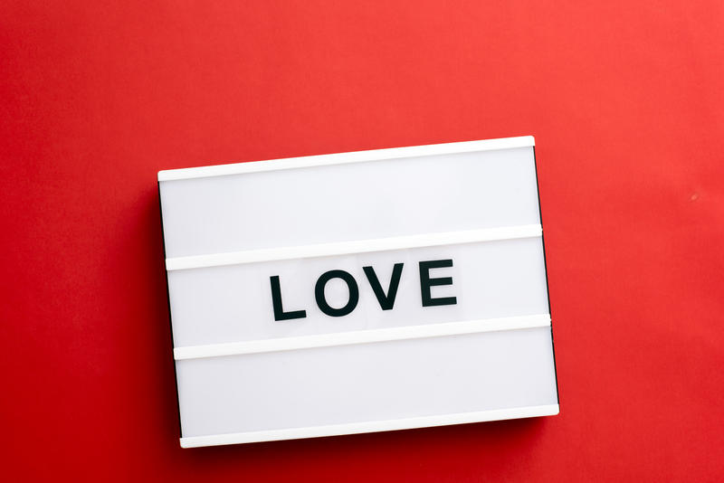 Valentines message to sweetheart of Love in black text on a small light box over a vivid red background conceptual of romance