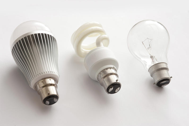 Three generations of light bulbs - LED, fluorescent and incandescent, in one row close-up on white background