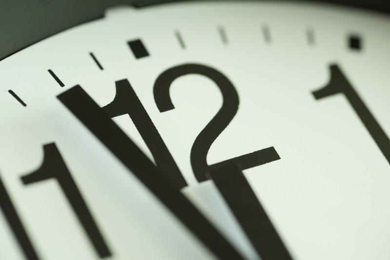 Countdown to New Years Eve midnight with a close up view of the hands of a clock approaching the twelve