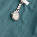 12953   Nurses silver fob watch pinned on a uniform