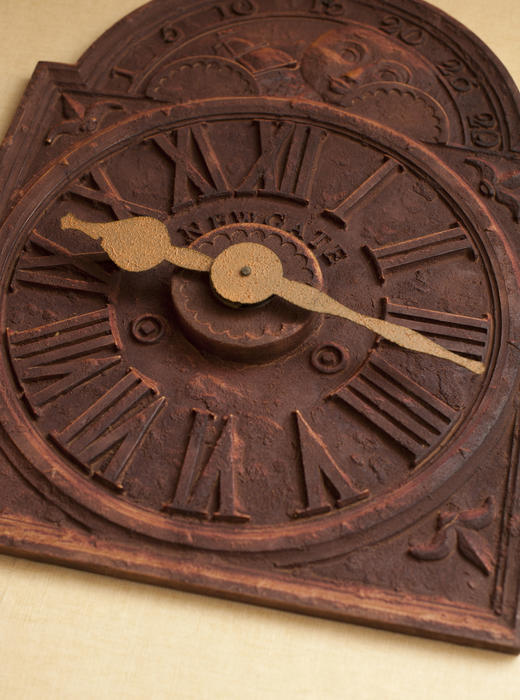 Close up view on old rusty clock with roman numerals and face at angle for concept about time and age