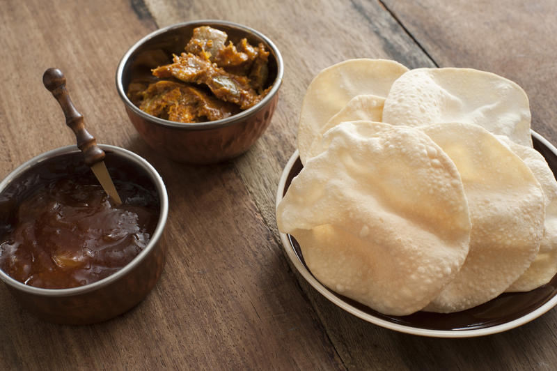 Papadums with chutney and spicy vegetables served in individual dishes ready to accompany an Indian curry
