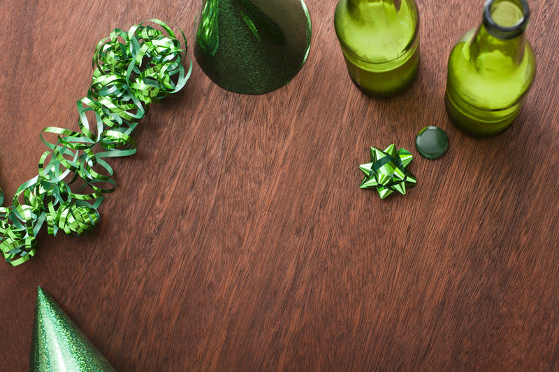 high angle view of beer bottles and green st. patricks day party decorations on a wooden table top