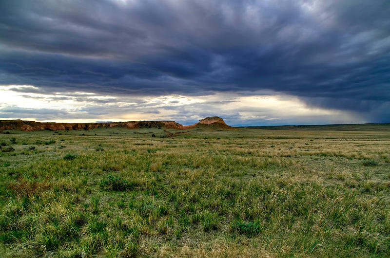 <p>Dark roiling clouds above a sweeping grass floor envelope rock formations creating an enchanted dreamlike visage. This is Pawnee National Grasslands, Colorado, during early spring. These grasslands are located on the Colorado prairie near the Wyoming state line.</p>
